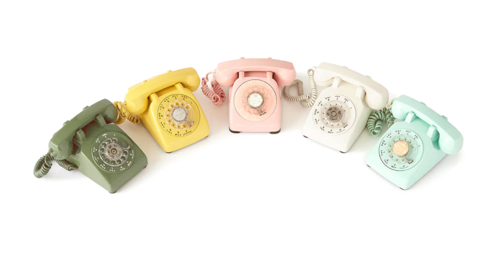 Five colorful vintage-style rotary phone models on a white background